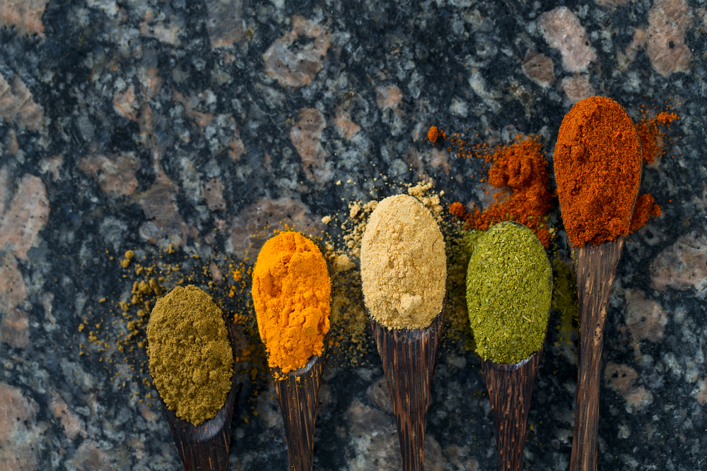 different spices in wooden spoons